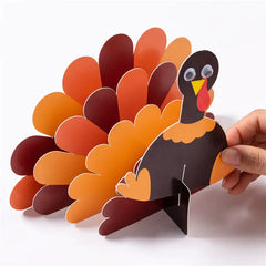 Hand holding a paper turkey craft on a white background