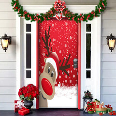 Decorative door with a cartoon reindeer face, red bow, and Christmas decorations on a house exterior.