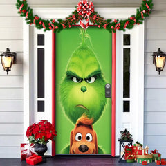 Decorative door with a green character and red bow, surrounded by Christmas decorations.