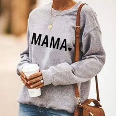 Person wearing a gray sweatshirt with 'MAMA' text, holding a coffee cup.